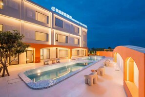 A hotel with a swimming pool, outdoor seating, and a modern architectural design. - MEI DI DU JIA HOTEL (Shanghai)
