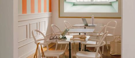 A study room with a large window, white chairs, a desk, and a laptop.