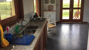 A kitchen with a gas stove, sink, and a dish rack. There is a window with a view of the outdoors. - La Ranita Negra Casa Mariposa by Interhome (La Paloma)