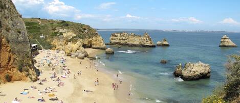 Une plage avec des formations rocheuses et une eau d’un bleu cristallin.