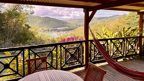 Una terraza de madera con vistas a un valle y montañas.