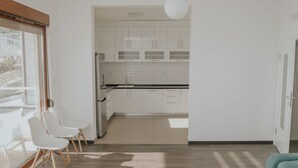 Une cuisine moderne avec des armoires blanches, un comptoir noir et une grande fenêtre.
