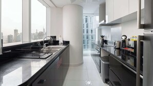 Una cocina moderna con un amplio ventanal, electrodomésticos de acero inoxidable y vistas a la ciudad.