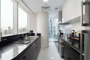 Eine moderne Küche mit großem Fenster, Edelstahlgeräten und Blick auf die Stadt.