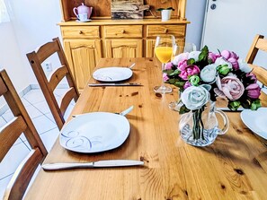 Ein Holztisch gedeckt mit Tellern, Besteck und einer Blumenvase.