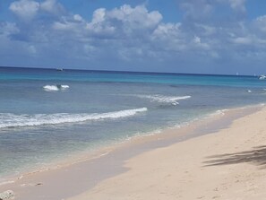 Uma praia com águas turquesa cristalinas e areal arenoso.