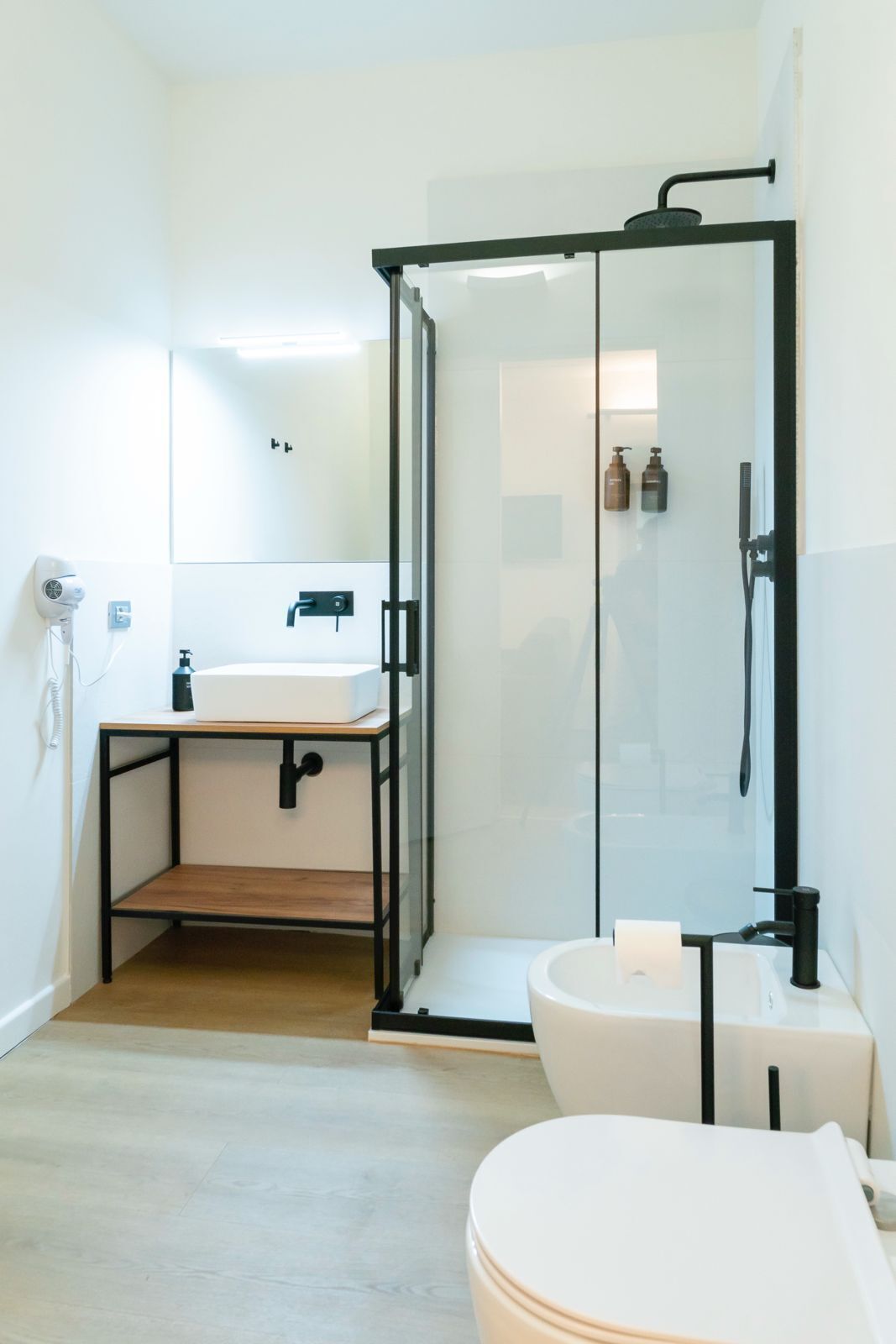 Une salle de bain moderne avec une douche à parois de verre, un lavabo blanc et des toilettes.