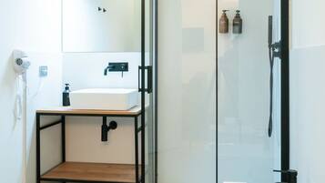 Une salle de bain moderne avec une douche à parois de verre, un lavabo blanc et des toilettes.