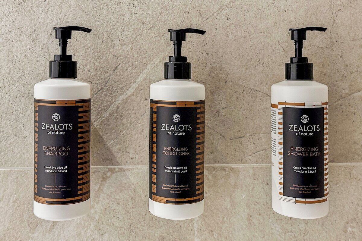 Three bottles of Zealots products: energizing shampoo, conditioner, and shower bath.