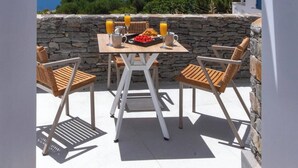 Una terraza con una mesa dispuesta para el desayuno, con vistas a un paisaje costero.