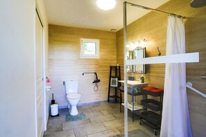 A bathroom with a toilet, a shower, a sink, and a mirror. - Holiday Home "Le Jardin" with Private Terrace and Wi-Fi (Lison)