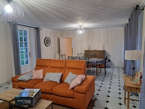 Un salon avec un canapé, une table à manger et un lustre.
