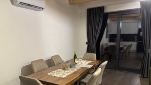 A dining area with a wooden table, six chairs, and a glass partition. - Rustic Authentic House, chalet style,  in charming Žabljak. (ZABLIJAK)