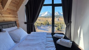 A bedroom with a large window, a bed, and a view of mountains. - Rustic Authentic House, chalet style,  in charming Žabljak. (ZABLIJAK)