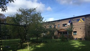 A building with a sign reading "AUTO CHECK M. FRIEDRICH" and a triangular warning sign. - Kastanienblick by Interhome (Ziethen)