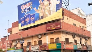 A hotel named "Hotel Shree Lodge" with a prominent billboard advertising "Cash & Gold" above the entrance. - Hotel Shree (Varanasi)