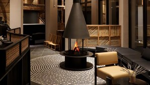 A modern interior with a central wood-burning stove, seating areas, and a high ceiling with exposed beams. - Chongqing Jinfo Cloudhaus Boutique Hotel (Chongqing)