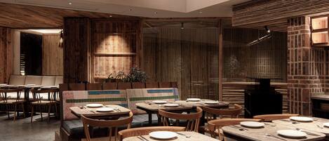 A restaurant with wooden tables and benches, a brick wall, and a fireplace.