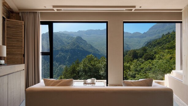 A bedroom with a large bed, two windows offering a mountain view, and a wooden headboard. - Chongqing Jinfo Cloudhaus Boutique Hotel (Chongqing)