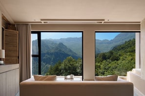 A bedroom with a large bed, two windows offering a mountain view, and a wooden headboard. - Chongqing Jinfo Cloudhaus Boutique Hotel (Chongqing)