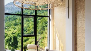 A modern lounge with a large window offering a view of a mountainous landscape, a woven ceiling light fixture, and contemporary seating. - Chongqing Jinfo Cloudhaus Boutique Hotel (Chongqing)