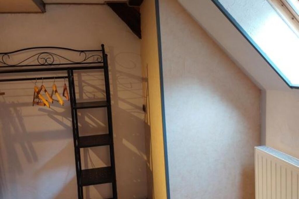 Una habitación con literas, una escalera y un radiador.