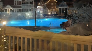 Ein Modell eines Resorts mit Swimmingpool, Holzterrasse und einem Chalet-Gebäude.