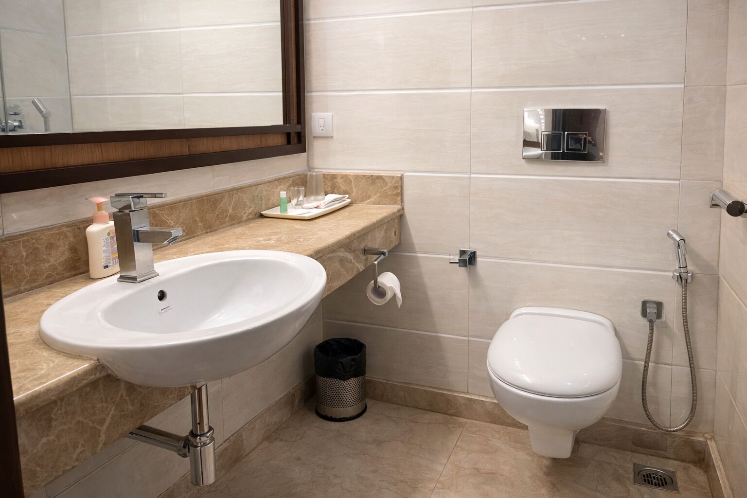 Een moderne badkamer met een wastafel, toilet en douche.