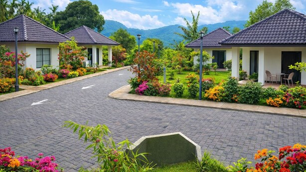 A residential area with two houses, paved roads, and lush gardens. - Sonemale Resort Chikmagalur (Mudigere)