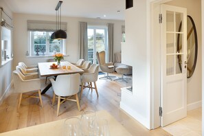 Un espace repas moderne comprenant une table, des chaises et un luminaire suspendu.