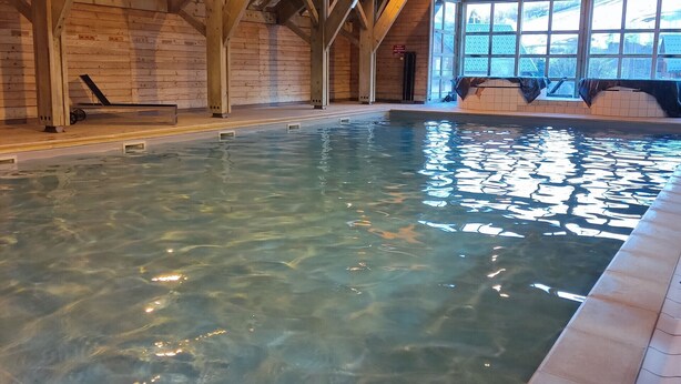 An indoor swimming pool with wooden beams and a tiled floor. - Nice Apt for 10 pers near the slopes (Saint-Sorlin-d´Arves)