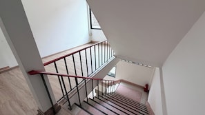 A staircase with a red handrail leading to an upper floor. - Brown H (Bangkok)