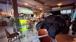 A room with a large vehicle, chairs, tables, and a bar area. - Brown H (Bangkok)