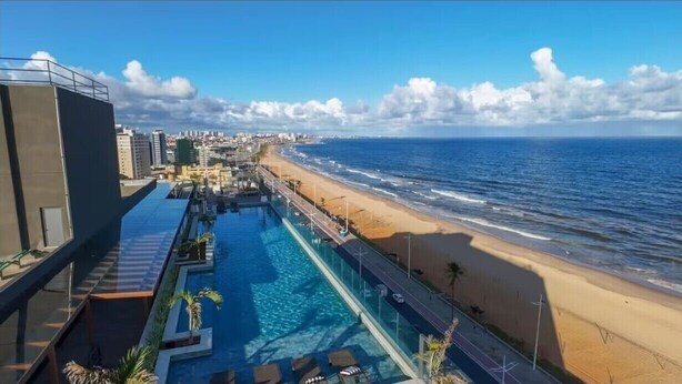 A rooftop pool with a view of the beach and ocean.