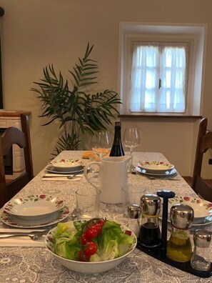 A dining table set with plates, cutlery, a pitcher, glasses, and a bowl of salad. - BORGO LA MORRA (Pavullo nel Frignano)