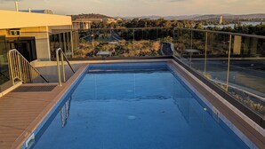 A swimming pool with a view of a cityscape in the background. - Centrally located new apartment with free parking and access of pool , gym (Canberra)