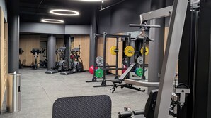 A gym with various exercise equipment, including weight machines and free weights. - Centrally located new apartment with free parking and access of pool , gym (Canberra)