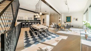 Ein modernes Interieur mit Treppe, Essbereich, Küche und Wohnbereich.