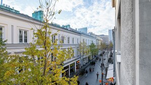 A street view with buildings, pedestrians, and trees. - RentPlanet - Apartament Chmielna (Warsaw)