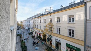 A street view with buildings, a café, and pedestrians. - RentPlanet - Apartament Chmielna (Warsaw)