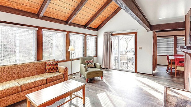 A spacious living room with a high ceiling, large windows, a sofa, a chair, and a dining area. - Family-Friendly Shenandoah Townhome – Near Lake Laura & Hiking Trails (Basye)