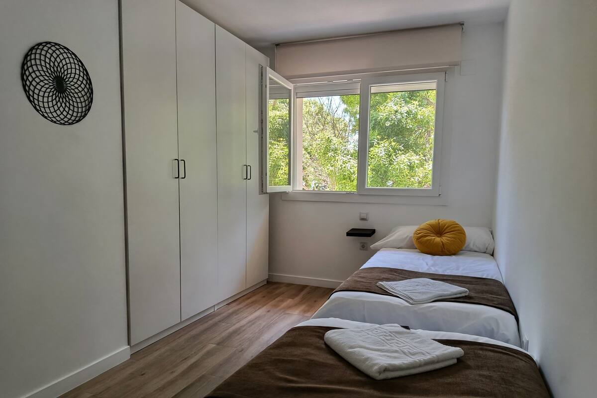 A bedroom with a bed, a window, and a wardrobe.