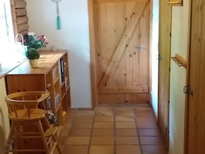 A narrow hallway with wooden flooring, a wooden door, and a small wooden stool. - "Kerrin" by Interhome (Aars)