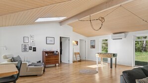 A spacious living area with a wooden ceiling, a foosball table, a sofa, a coffee table, and a dining area with a table and chairs. - "Aiko" - 1.8km from the sea by Interhome (Højby)