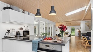A modern kitchen with a central island, built-in appliances, and pendant lighting. - "Aiko" - 1.8km from the sea by Interhome (Højby)