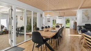 A modern interior with a wooden dining table, black chairs, and a large window. - "Aiko" - 1.8km from the sea by Interhome (Højby)