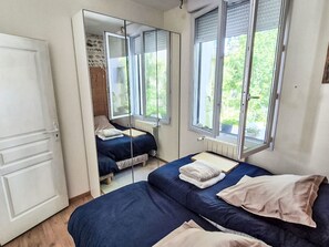 Ein Schlafzimmer mit einem Bett, einem Spiegel und einem Fenster.