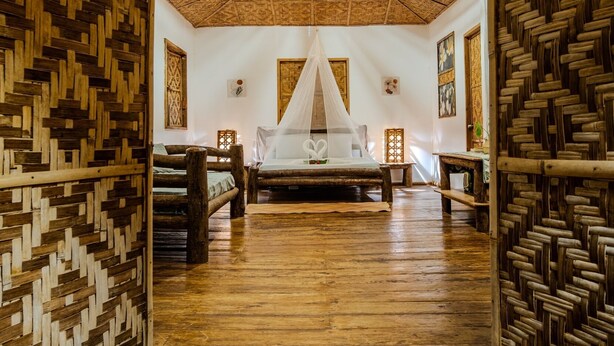 A room with a thatched roof, wooden floors, a bed with a canopy, and woven wooden walls. - om horizon ecoresort (Loay)