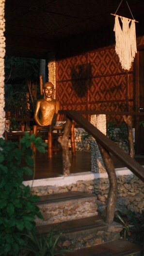 A Buddha statue in a serene setting with a patterned wall and stone steps. - om horizon ecoresort (Loay)