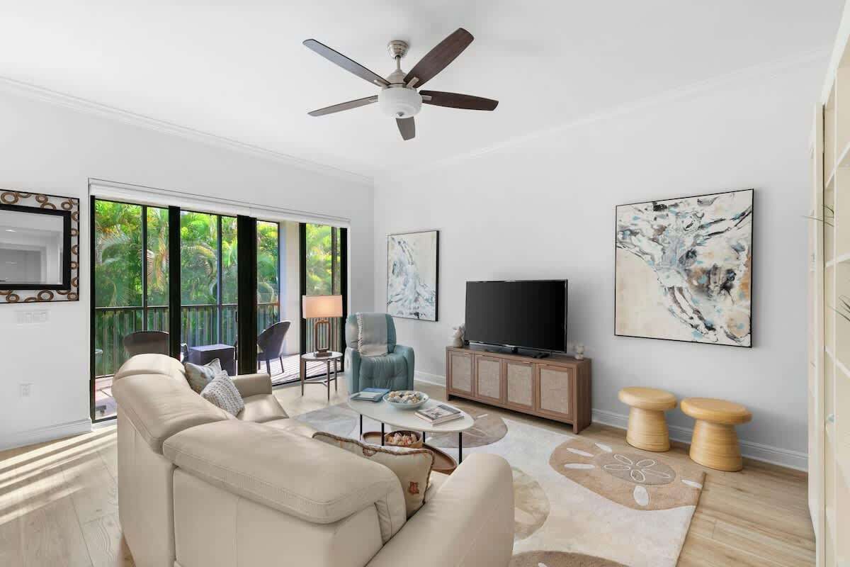 A living room with a sofa, coffee table, TV, and artwork on the wall.